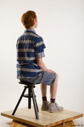 Sitting reference of whole body striped blue gray shirt blue jeans shorts black gray shoes Wesley